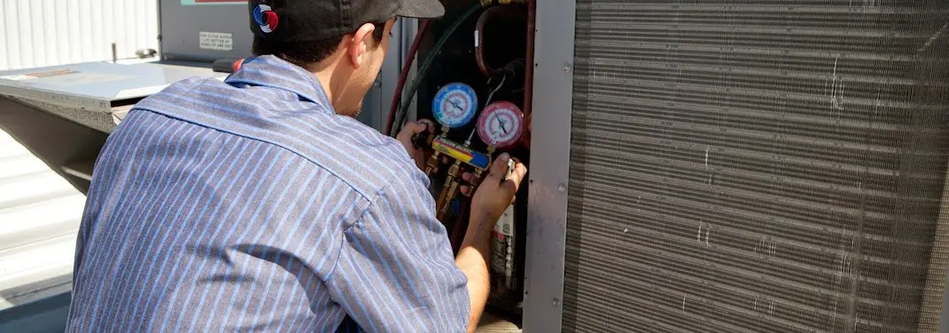 HVAC technician servicing a condenser unit in North Lebanon